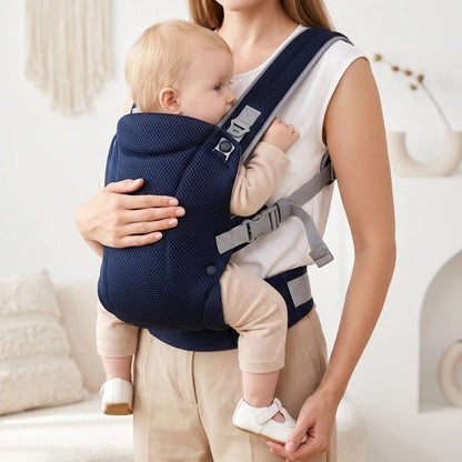 Porte-bébé mesh bleu marine avec bretelles croisées et réglables, porté face au porteur en intérieur