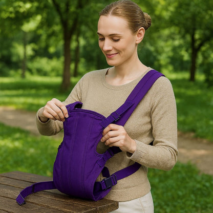 Porte bébé physiologique violet posé à plat sur une table, femme ajustant les sangles avant installation