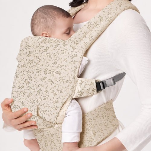 Porte bebe preforme beige fleuri porté devant, vue de profil avec ceinture large