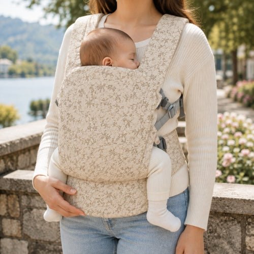 Porte bebe preforme beige fleuri porté devant pendant une promenade au bord de l’eau