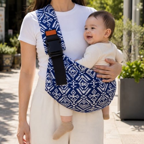 Porte-bébé souple à une épaule bleu à motif géométrique avec boucle réglable, port latéral en ville