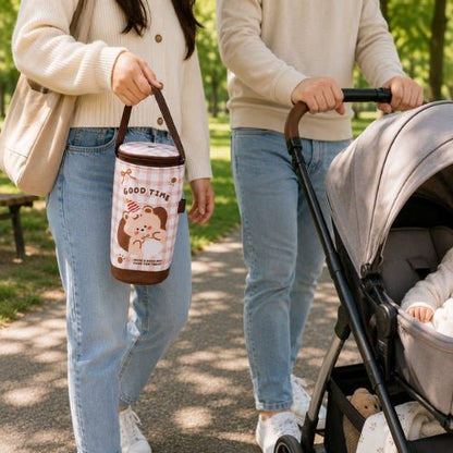 Sac à carreaux pour biberon à motifs animaux porté à la main pendant une sortie