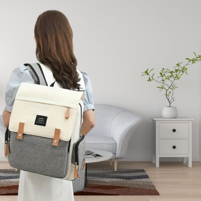 Sac à dos à langer beige et gris, conçu pour une efficacité maximale avec un accès facile aux affaires de bébé