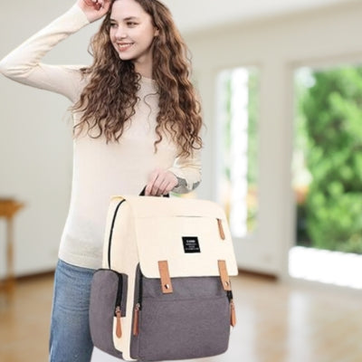 Sac à dos à langer beige et gris offrant une solution pratique avec des poches multiples pour organiser les essentiels de bébé