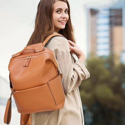 Sac à dos à langer brun élégant, porté par une femme avec style pour allier confort et organisation au quotidien.