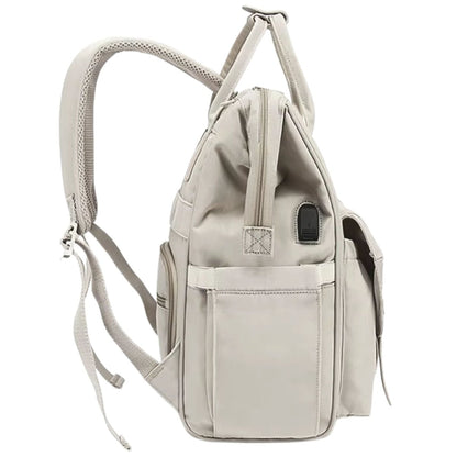Sac à dos à langer beige avec port USB visible et poche latérale extensible