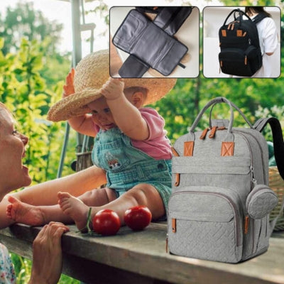 Une famille en plein air utilisant le sac à dos à langer gris SacDouillet™, illustrant sa polyvalence pour toutes les occasions