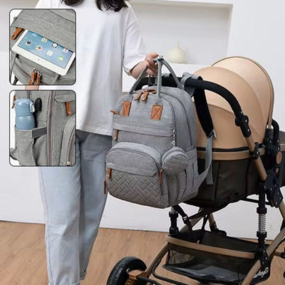 Sac à dos à langer gris SacDouillet™ attaché à une poussette, mettant en avant ses sangles pratiques pour une organisation optimale