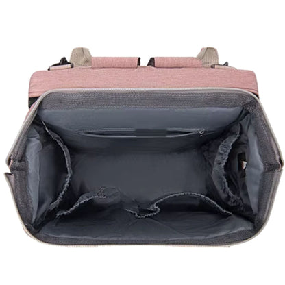 Sac à dos à langer en face avec poche principale ouverte contenant des accessoires