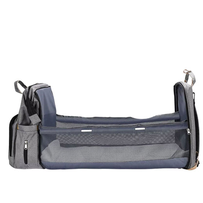 Sac à dos à langer transformé en lit ouvert, avec matelas intégré visible