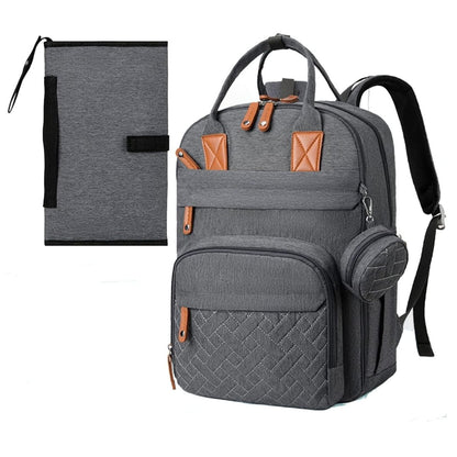 Sac à dos à langer posé de face avec tapis à langer assorti déplié devant