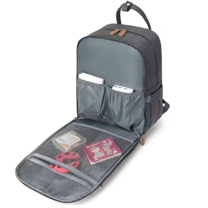 Sac à dos à langer avec grande poche avant totalement ouverte montrant les rangements