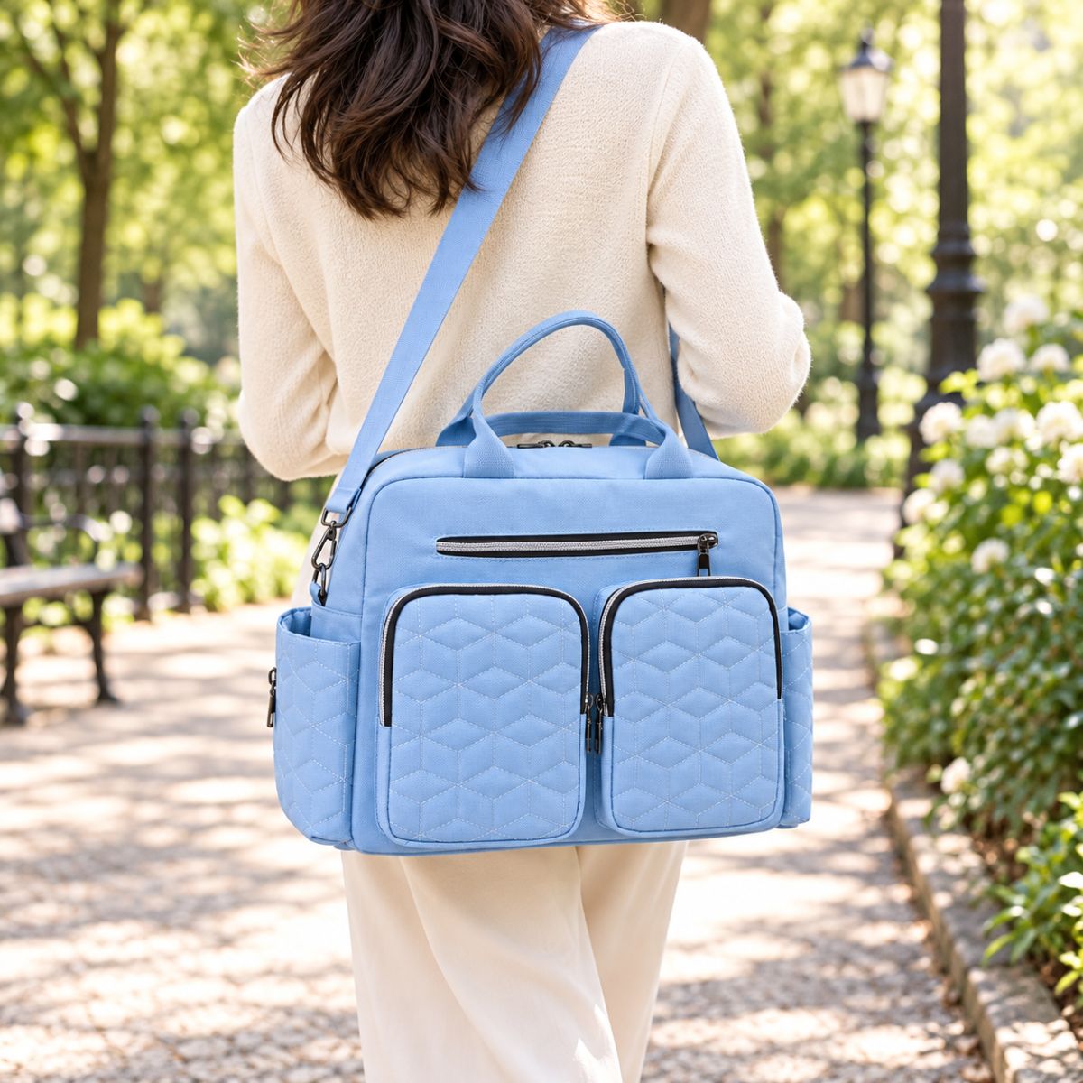 Sac à langer Double poche avant Bleu ciel porté en bandoulière pendant une promenade
