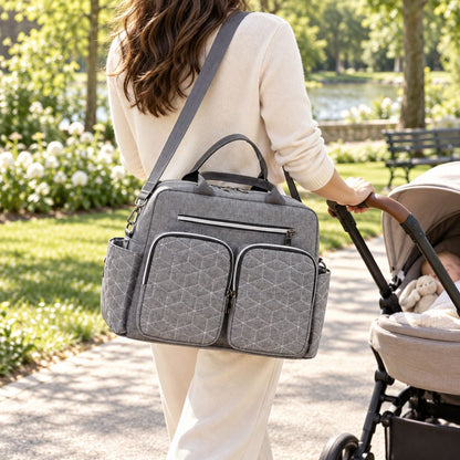 Sac à langer Double poche avant Gris porté en bandoulière près d’une poussette