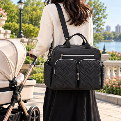 Sac à langer Double poche avant Noir porté en bandoulière près d’une poussette