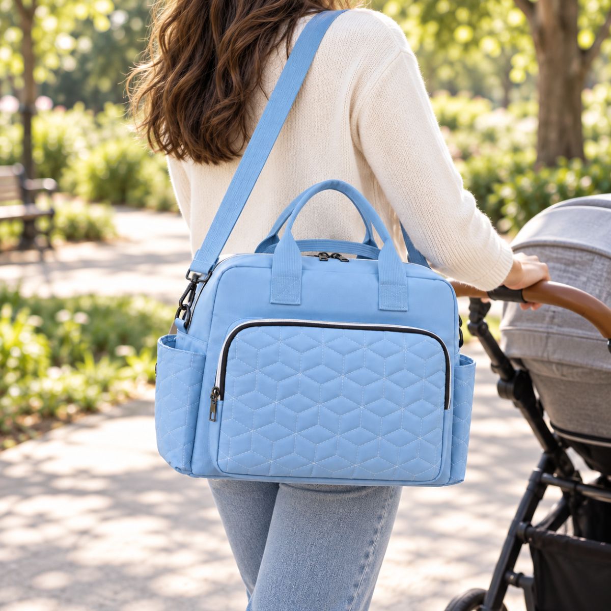Sac à langer Grande poche avant Bleu ciel porté en bandoulière pendant une promenade