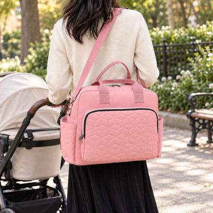 Sac à langer Grande poche avant Rose porté en bandoulière pendant une promenade