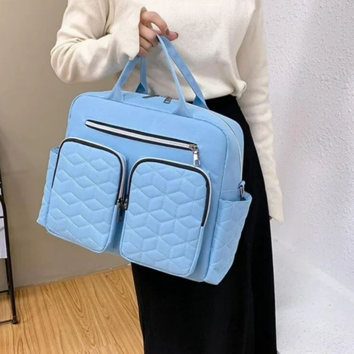 Sac a langer bleu ciel porté à la main avec double poche avant zippée