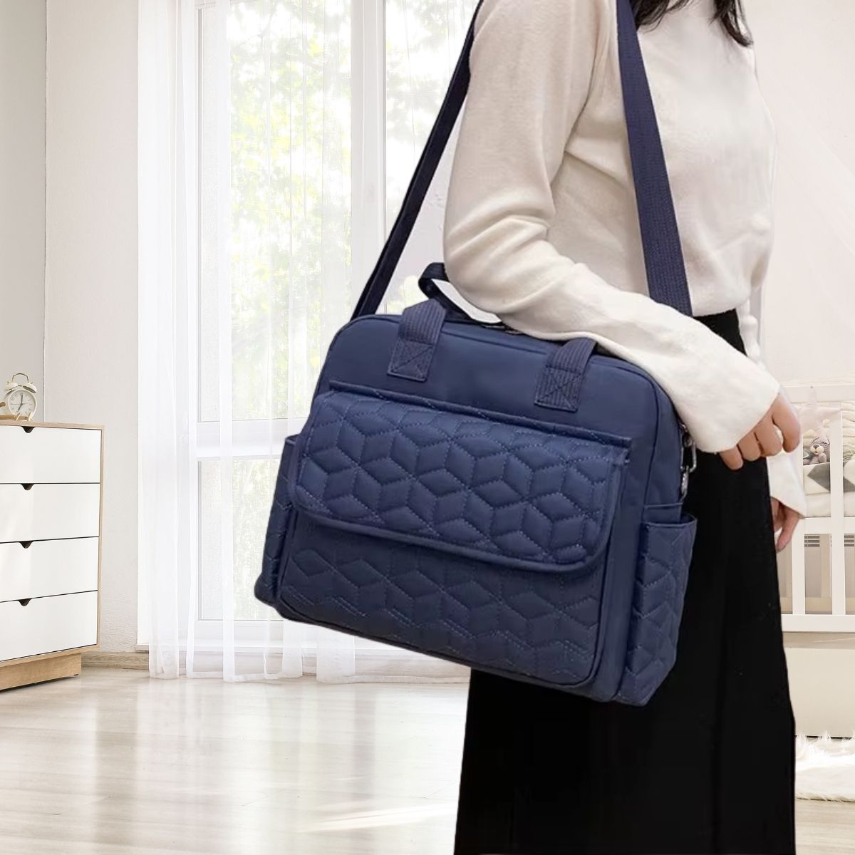 Sac a langer bleu foncé porté en bandoulière par une maman