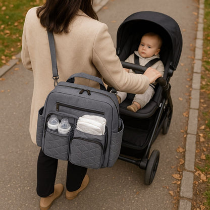 Sac a langer gris porté en bandoulière sur poussette avec biberons et couches rangés
