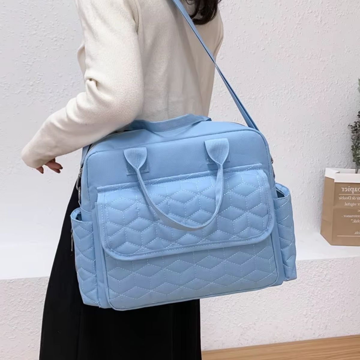 Sac a langer bleu ciel porté en bandoulière par une maman