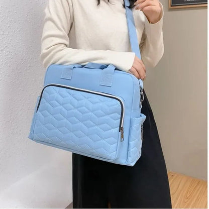 Sac a langer bleu ciel porté à l’épaule, modèle compact pour sorties