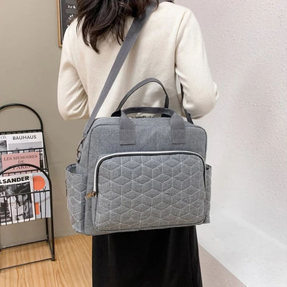 Sac a langer gris porté en bandoulière par une maman