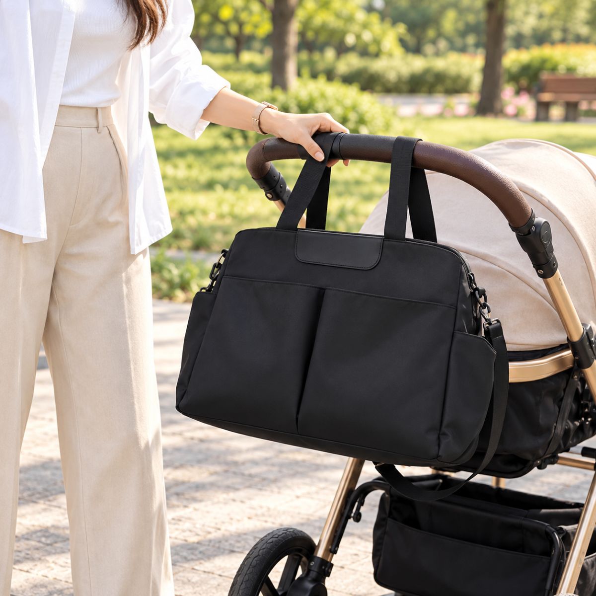Sac à langer avec tapis de change noir présenté près d’une poussette