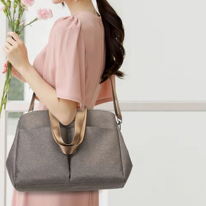 Sac à langer avec tapis de change taupe porté avec sa bandoulière