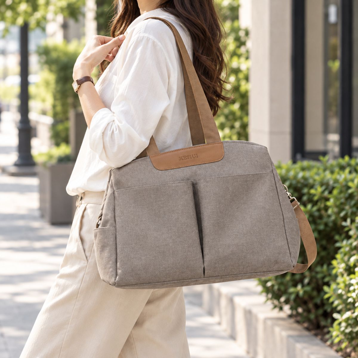 Sac à langer avec tapis de change taupe vu de face et porté à l’épaule