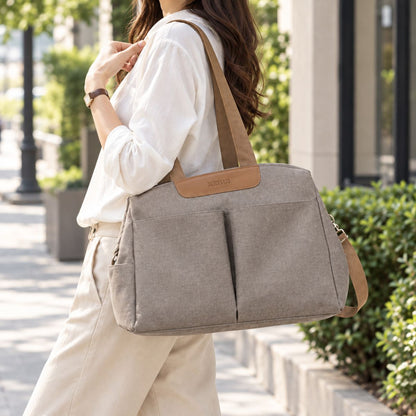 Sac à langer avec tapis de change taupe vu de face et porté à l’épaule