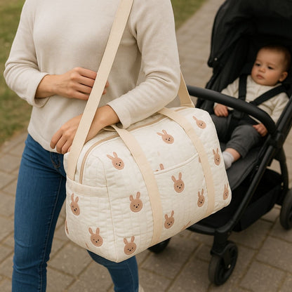 sac a langer bebe lapins brodés porté à l’épaule par une maman devant une poussette