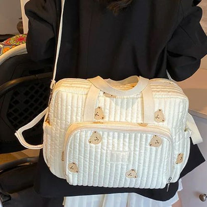 Sac a langer ourson vu de dos, bandoulière longue et forme stable sur robe à pois