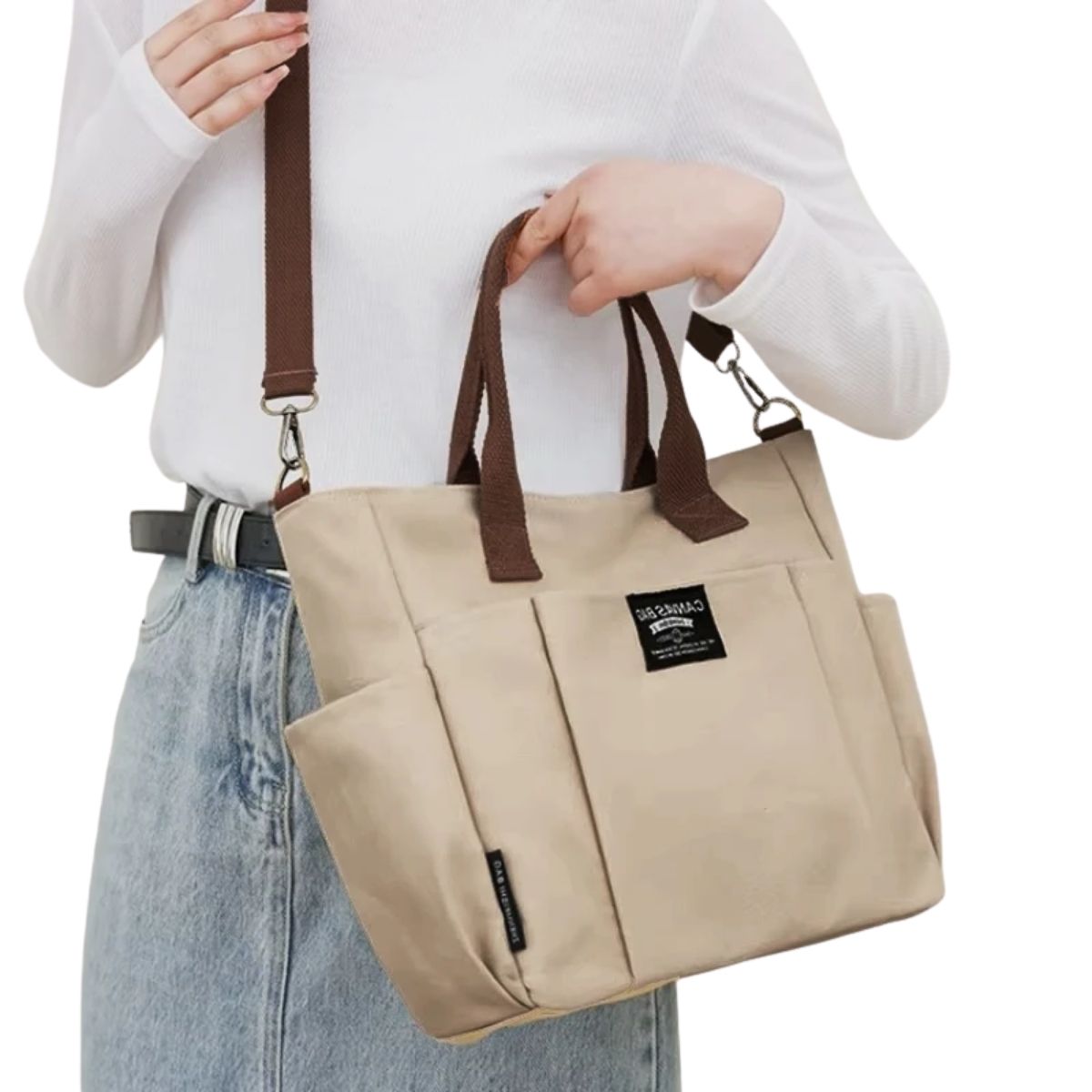 Sac a langer compact kaki porté en bandoulière par une femme, idéal pour sorties rapides