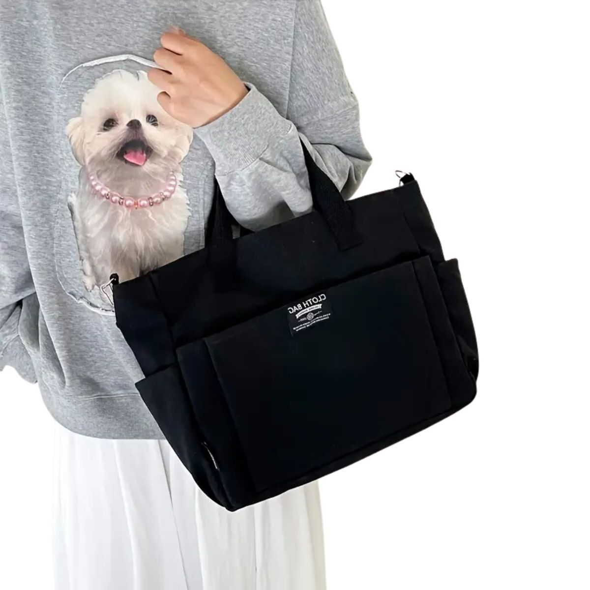 Sac a langer compact noir porté à l’épaule avec anses solides et format pratique