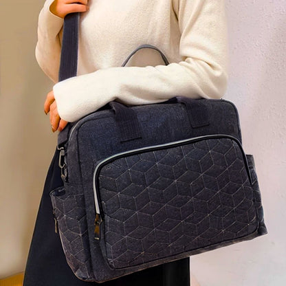 Sac a langer noir porté à l’épaule avec rabat avant matelassé