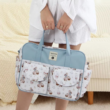 Sac à langer grande capacité Lapin de Pâques porté à la main par une maman en intérieur