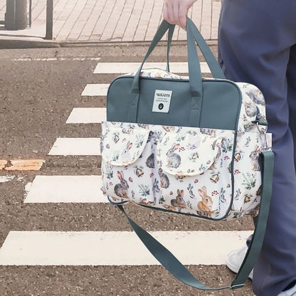 Sac a langer grande capacite lapin de Noël porté à la main en extérieur avec bandoulière bleue