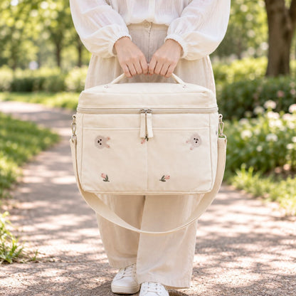 Sac à langer isotherme lapin beige porté à la main en extérieur