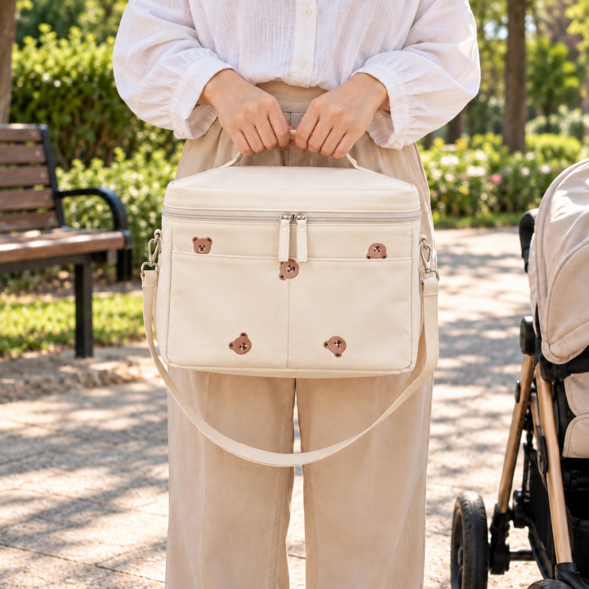 Sac à langer isotherme ours beige porté à la main en extérieur