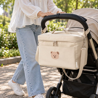 Sac à langer isotherme ours beige uni installé sur une poussette en extérieur