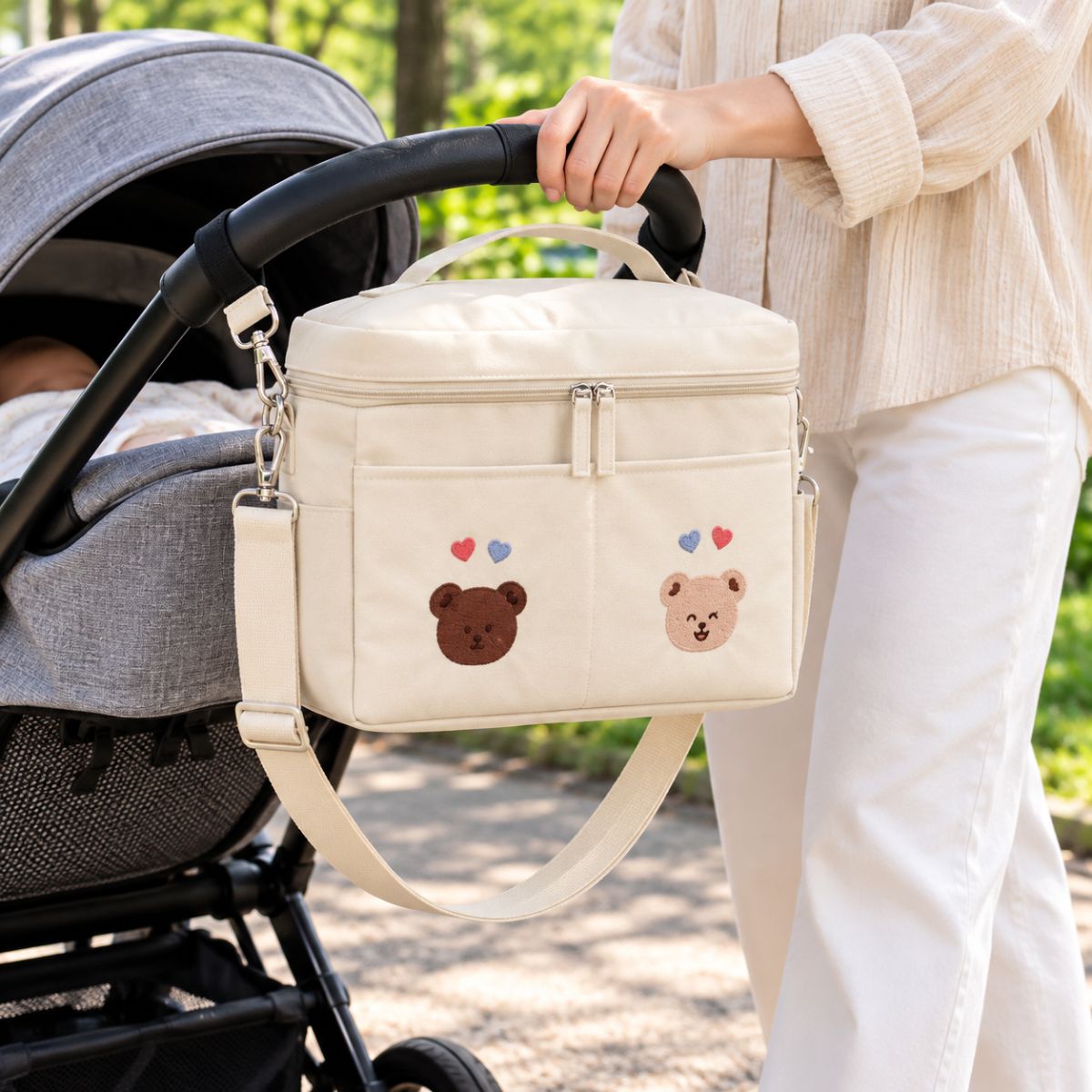 Sac à langer isotherme ours duo beige présenté près d’une poussette en extérieur