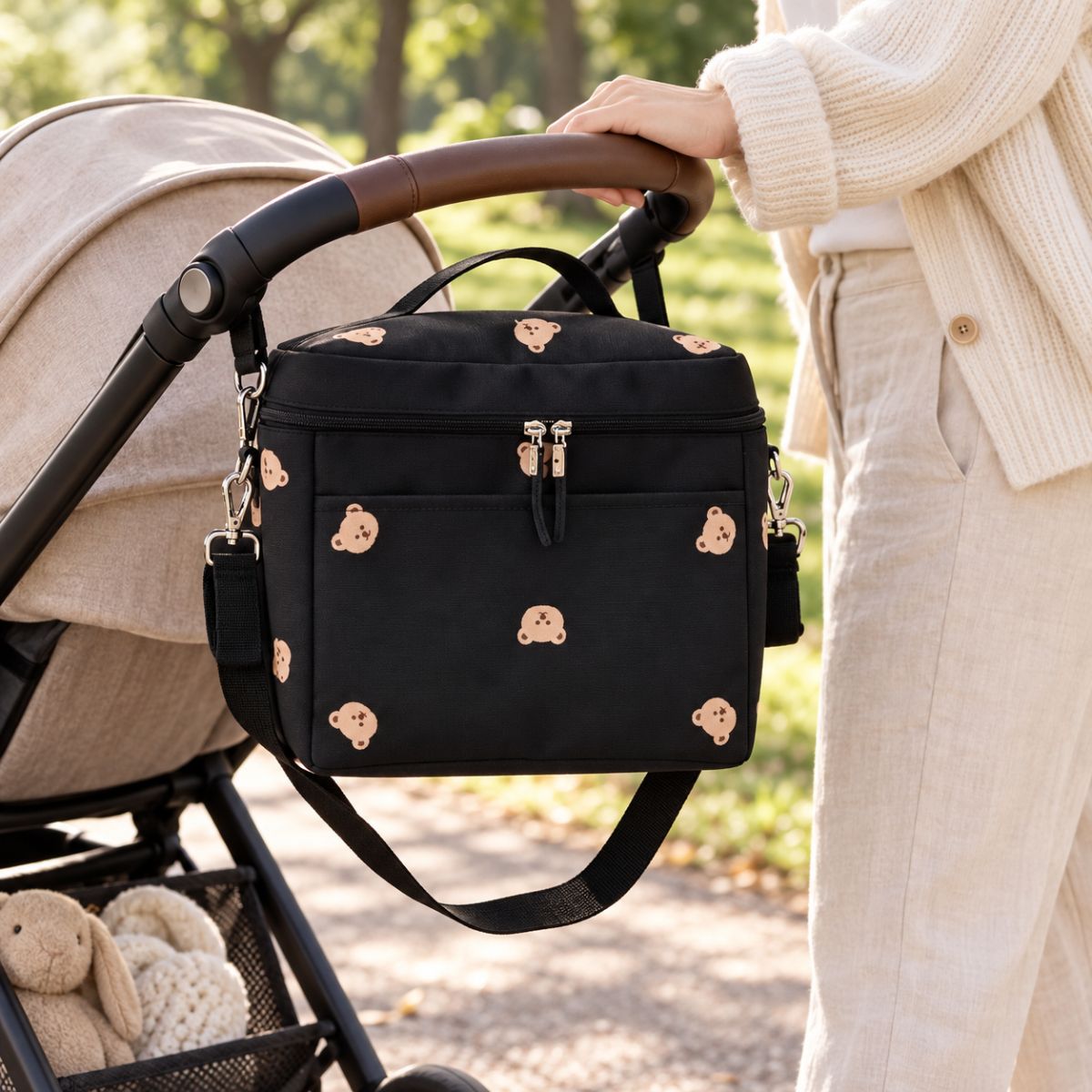 Sac à langer isotherme ours noir installé sur une poussette en extérieur