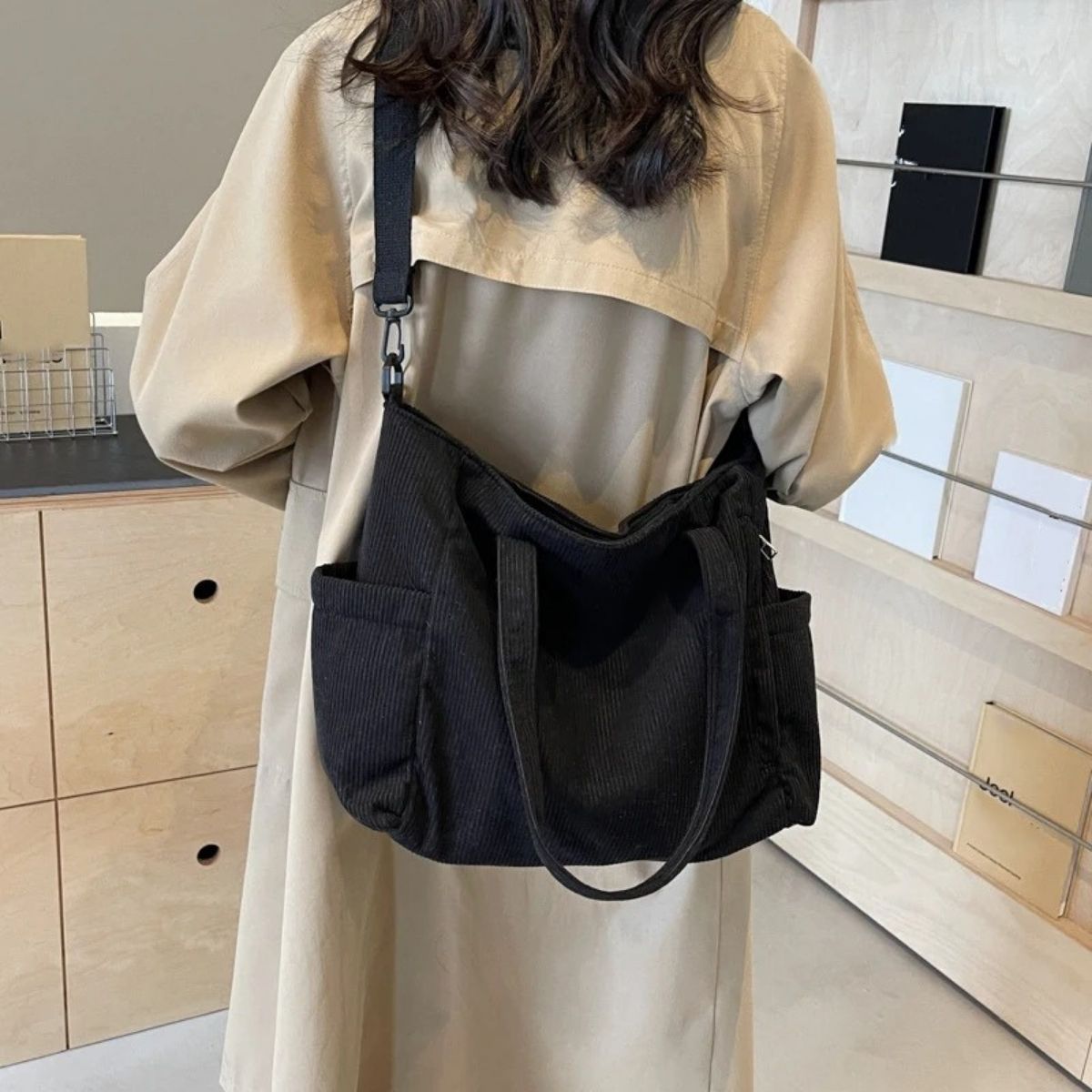 Sac à langer noir vu de dos porté sur l’épaule, format pratique avec poches latérales