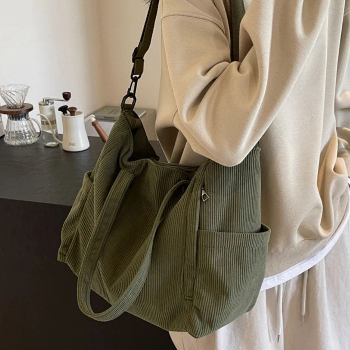 Sac à langer vert porté à l’épaule, design côtelé pratique pour les sorties avec bébé