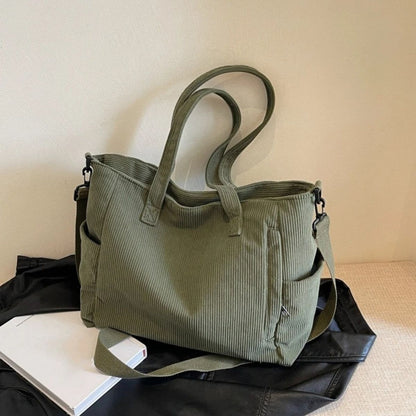 Sac à langer vert sur une surface claire, design pratique avec poches latérales