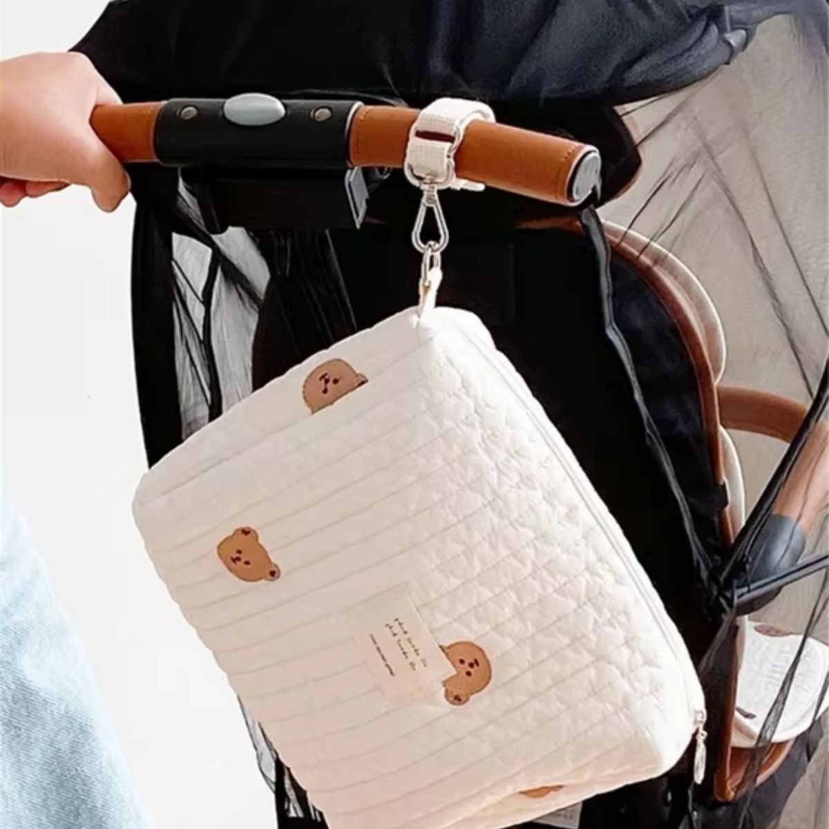 Sac à langer matelassé Petit Ourson suspendu à une poussette avec son attache