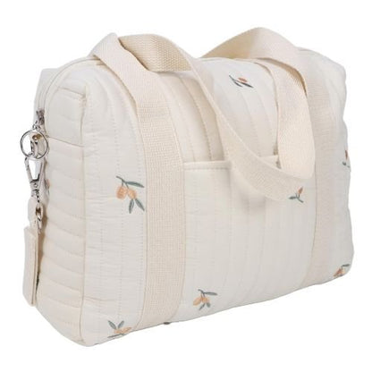 sac a langer à motif feuillage d’olivier, placé sur une table en bois clair