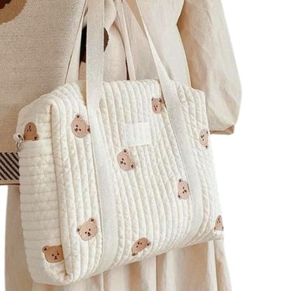 sac a langer crème brodé de têtes de grand ourson, porté à l’épaule par une maman