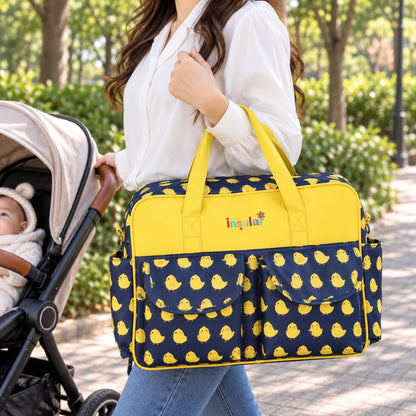 Sac à langer multipoches motif Adorable poulet jaune et bleu marine porté à la main près d’une poussette